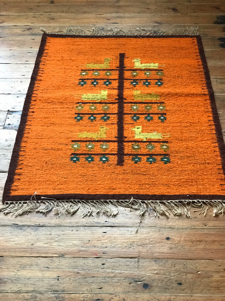 Orange wool rug with white fringe