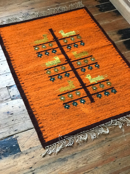 Orange wool rug with white fringe