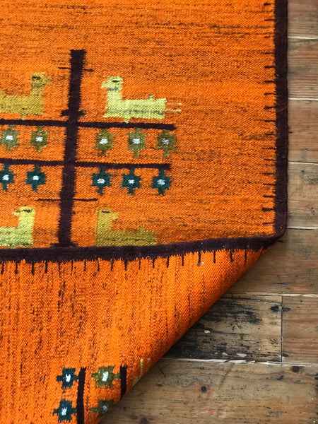 Orange wool rug with white fringe